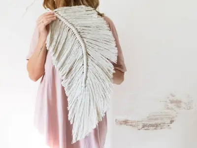 Tapiz con forma de hoja de macramé terminada preparada para colgar en la pared como resultado del primer curso