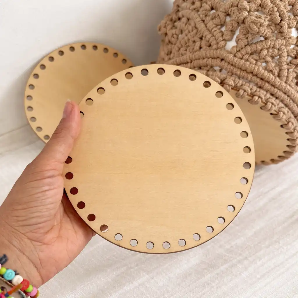 Base de madera perforada para macramé sostenida en mano mostrando tamaño real